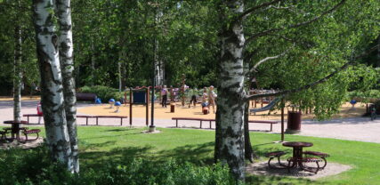 Vistelseområde i trädens skugga i Thurmansparken. I bakgrunden syns lekparken.