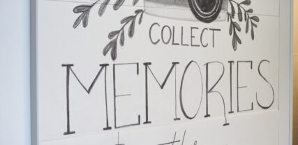 Tavla med kamera och blommor och texten: collect memories not things